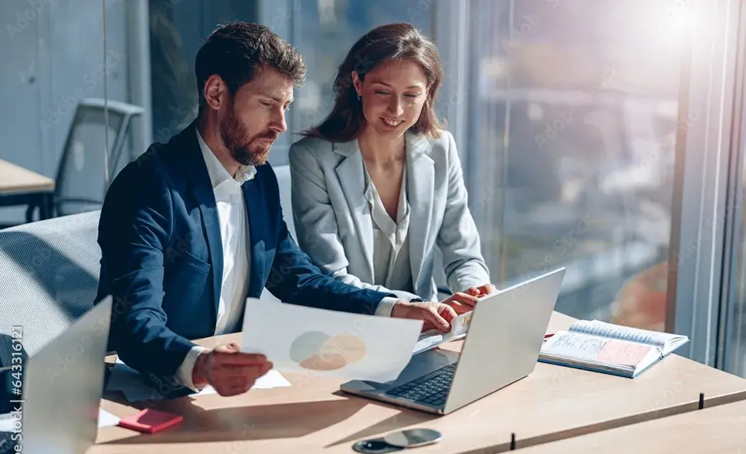 Business analysts reviewing claims performance reports